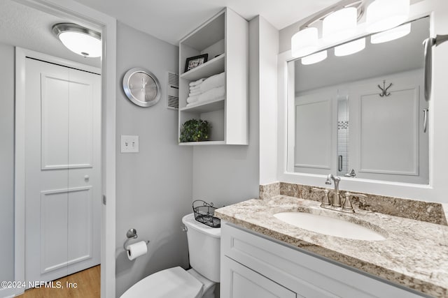 bathroom with vanity, toilet, and hardwood / wood-style flooring