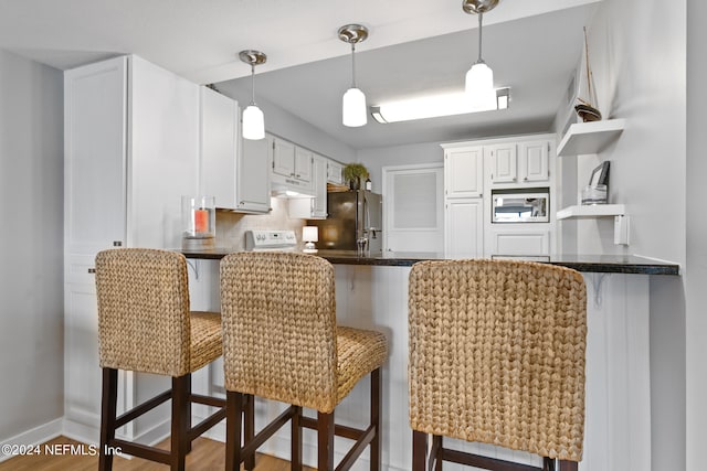 kitchen featuring appliances with stainless steel finishes, white cabinets, and kitchen peninsula