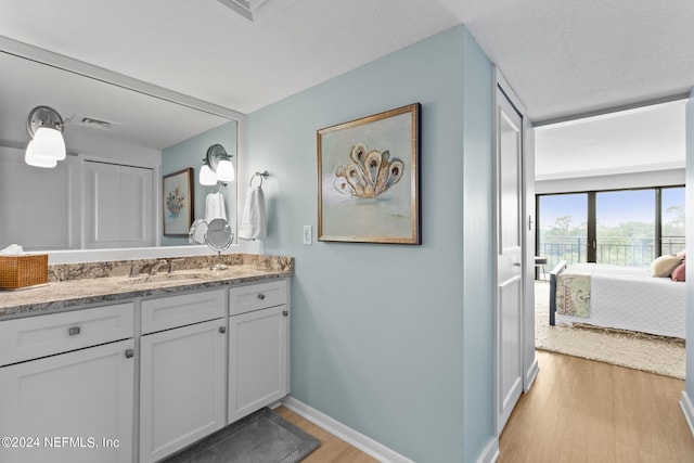 bathroom featuring a textured ceiling, wood-type flooring, and oversized vanity