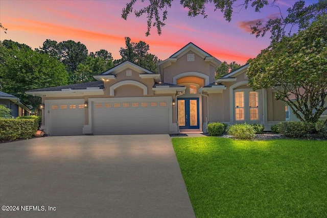 view of front facade with a garage and a yard