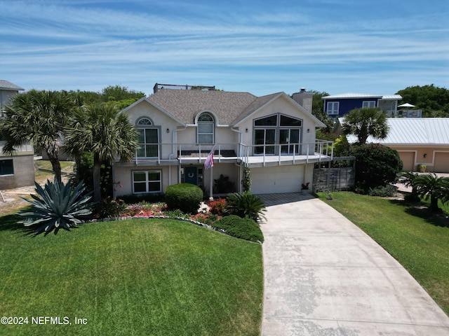 view of front of house featuring a garage, a balcony, and a front yard