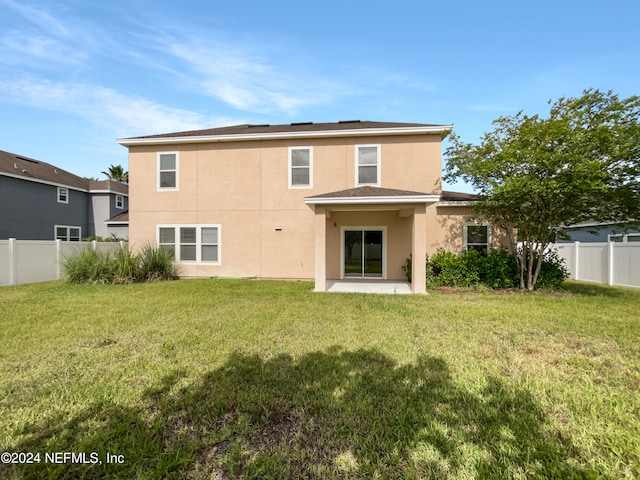 rear view of house featuring a patio and a yard