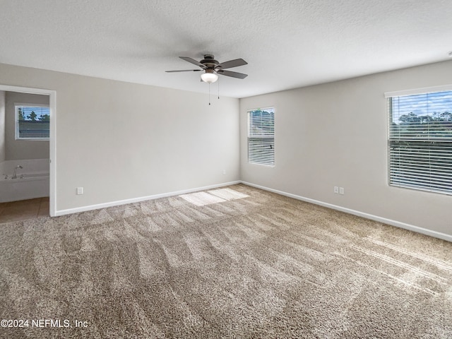 carpeted spare room with a textured ceiling and ceiling fan