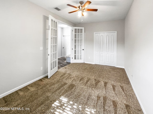 unfurnished bedroom with a closet, french doors, carpet flooring, and ceiling fan