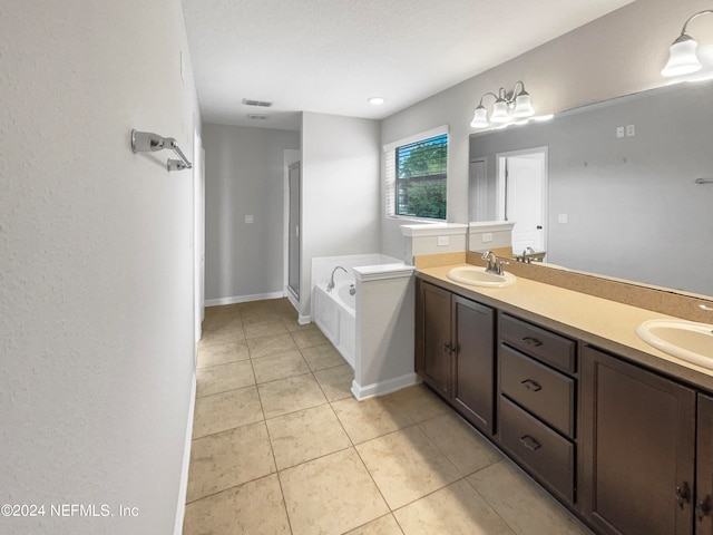 bathroom with a bathing tub, tile floors, a textured ceiling, and double sink vanity