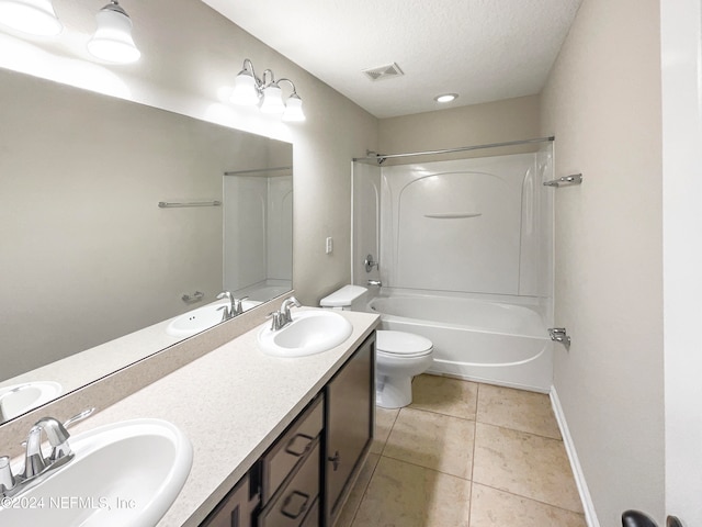 full bathroom with shower / bathing tub combination, tile floors, double sink vanity, toilet, and a textured ceiling