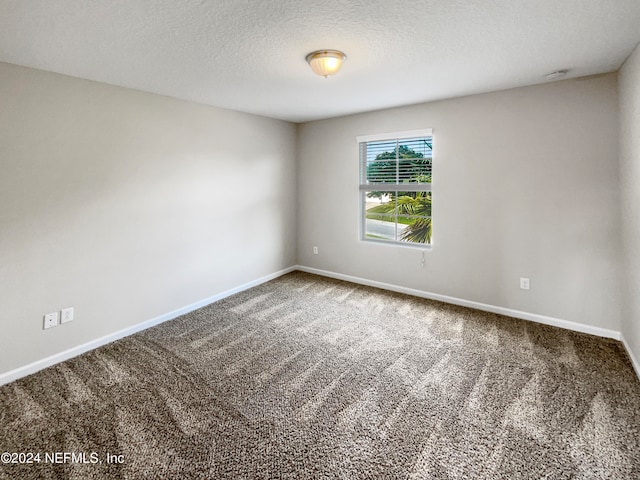 carpeted spare room with a textured ceiling