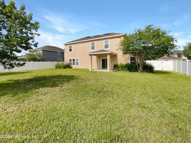 rear view of house with a lawn