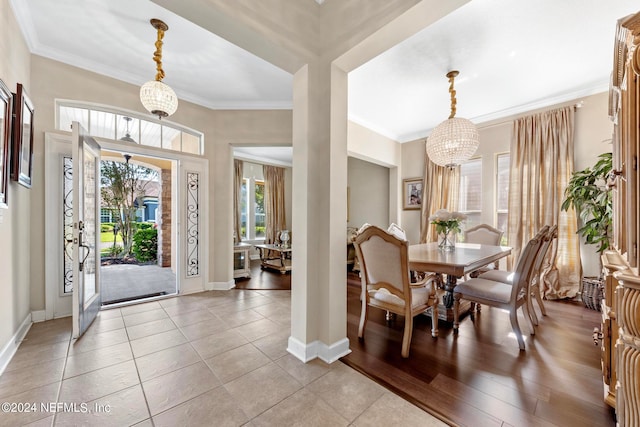 dining space featuring a chandelier, ornamental molding, and light wood-type flooring