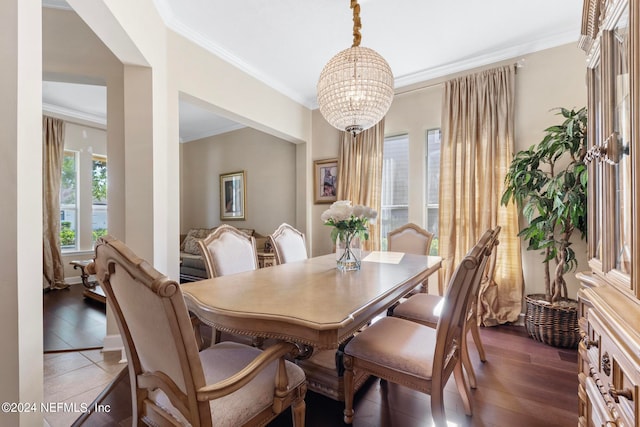 dining room with dark tile floors, a chandelier, and ornamental molding