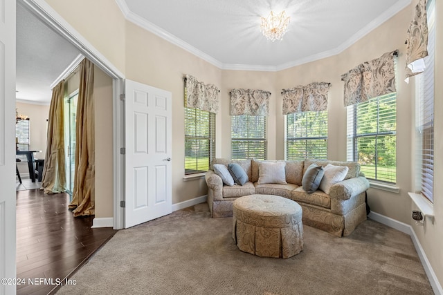 carpeted living room featuring crown molding and a chandelier