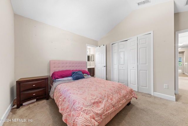 bedroom featuring lofted ceiling, a closet, and carpet flooring