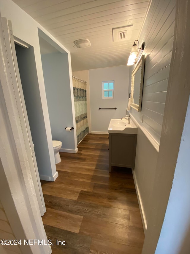 bathroom with wood-type flooring, vanity, and toilet