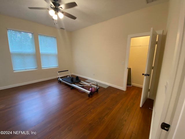 workout area with dark hardwood / wood-style floors and ceiling fan