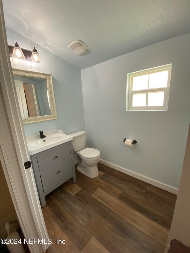 bathroom featuring hardwood / wood-style floors, oversized vanity, and toilet