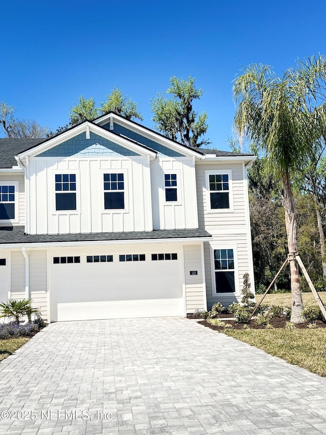 view of front of property with decorative driveway, board and batten siding, and an attached garage