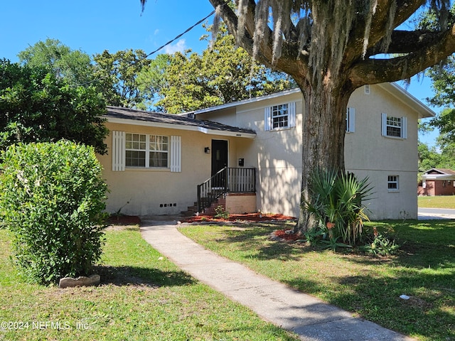 tri-level home with a front lawn