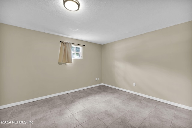 unfurnished room with a textured ceiling