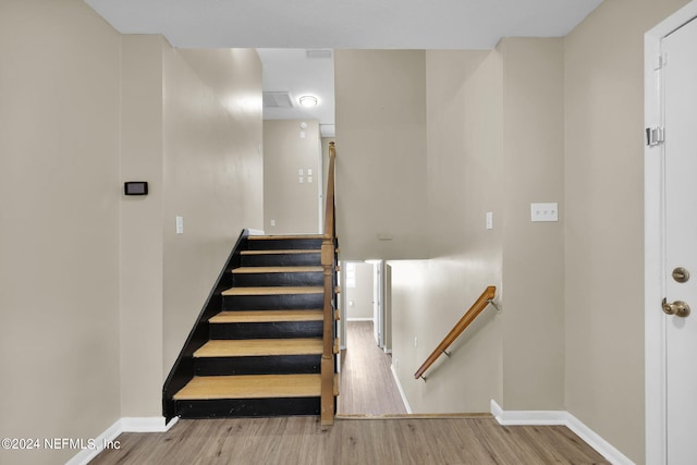 stairway with hardwood / wood-style flooring