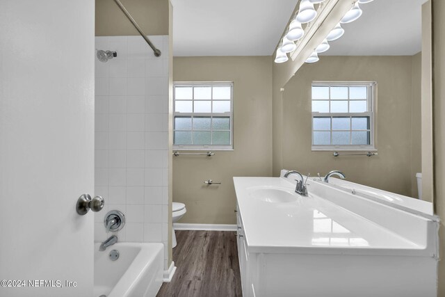 full bathroom featuring toilet, vanity, tiled shower / bath combo, and hardwood / wood-style floors