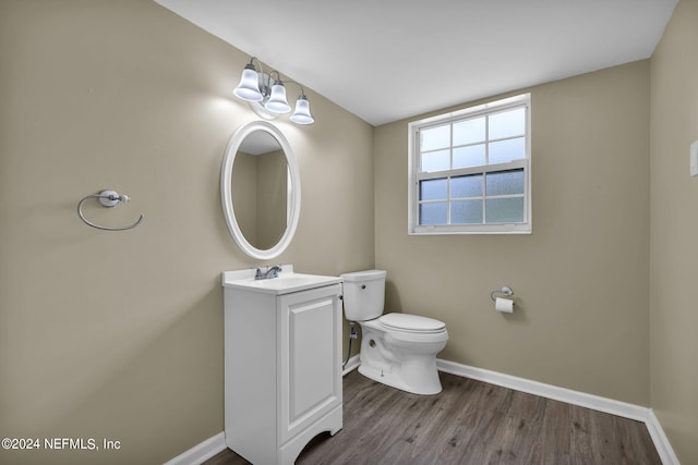 bathroom featuring wood-type flooring, toilet, and vanity