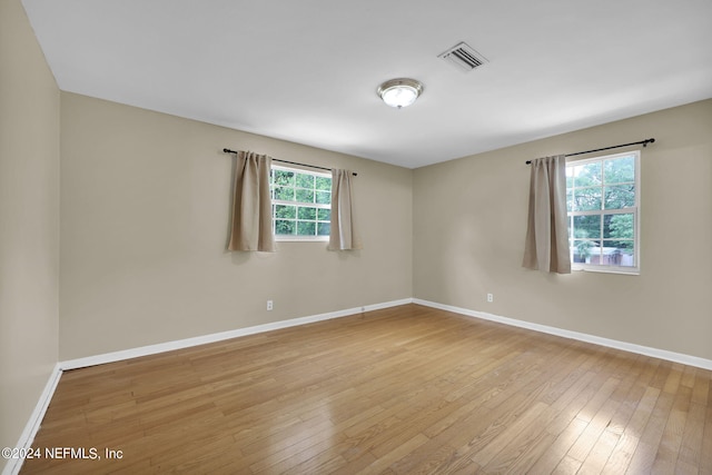 spare room with a healthy amount of sunlight and light hardwood / wood-style flooring