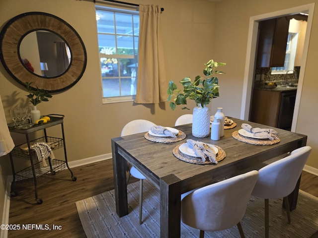 dining area with dark hardwood / wood-style floors and sink