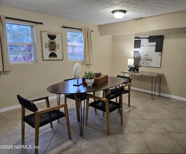 tiled dining area featuring a textured ceiling