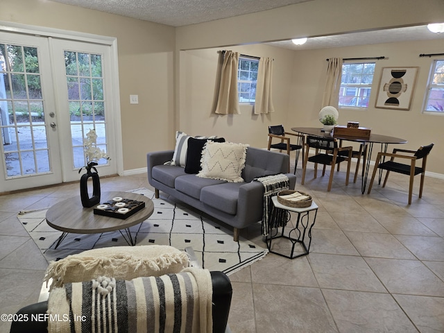 living room with a textured ceiling, light tile patterned flooring, and french doors