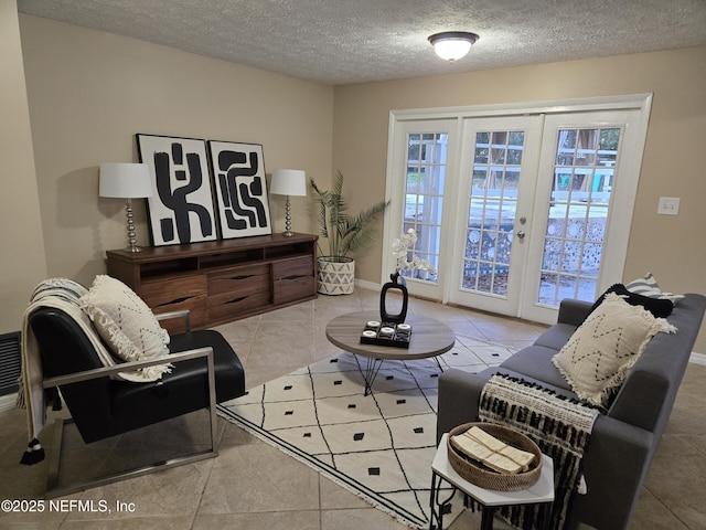 living area featuring a textured ceiling, tile patterned floors, and french doors