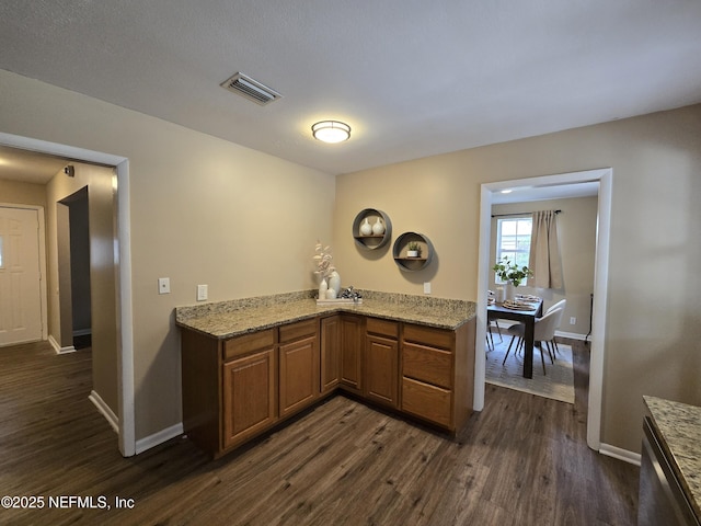 kitchen featuring dark wood-type flooring and light stone counters