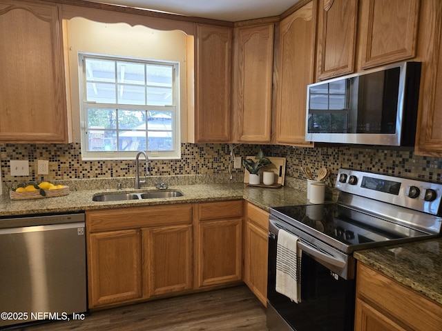 kitchen with decorative backsplash, sink, stone countertops, and stainless steel appliances