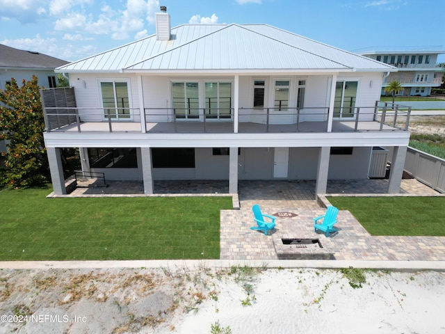 back of house with a yard, a fire pit, and a patio