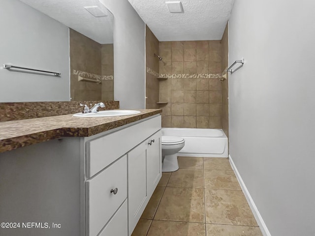 full bathroom with toilet, vanity, tiled shower / bath, tile patterned floors, and a textured ceiling