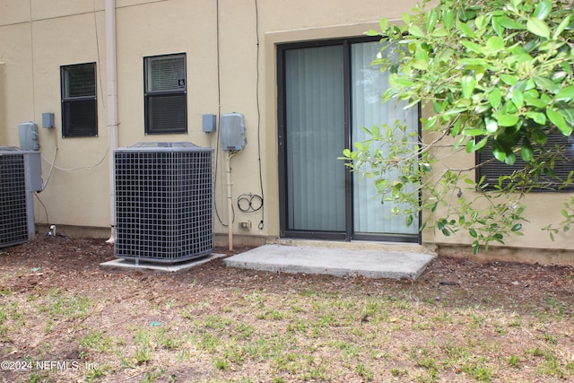 doorway to property with stucco siding and central air condition unit