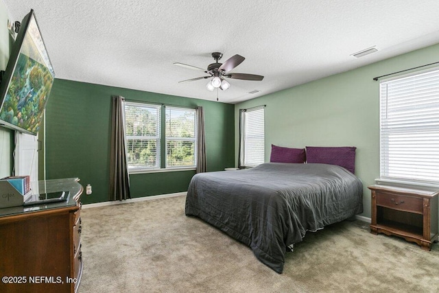 bedroom featuring a textured ceiling, visible vents, carpet flooring, and baseboards