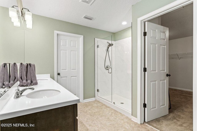 bathroom with visible vents, a stall shower, a notable chandelier, and a sink