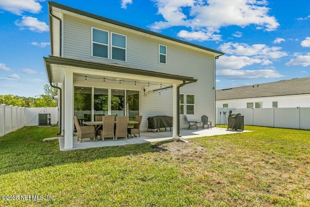 rear view of property with a fenced backyard, a yard, a patio area, and cooling unit