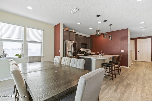 dining space featuring light wood-type flooring, visible vents, and recessed lighting