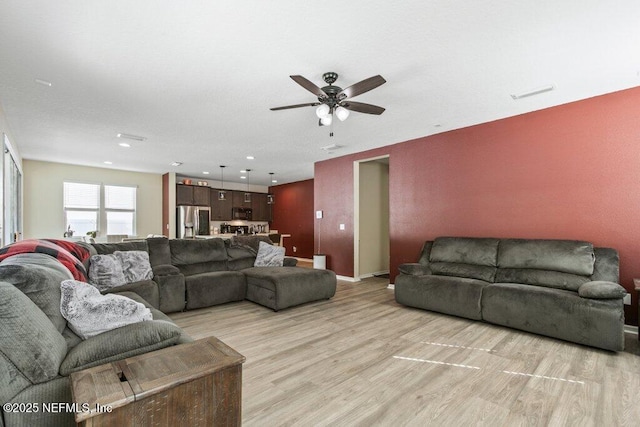living area with a ceiling fan, light wood-style flooring, baseboards, visible vents, and recessed lighting