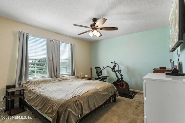 carpeted bedroom with a textured ceiling, baseboards, and ceiling fan