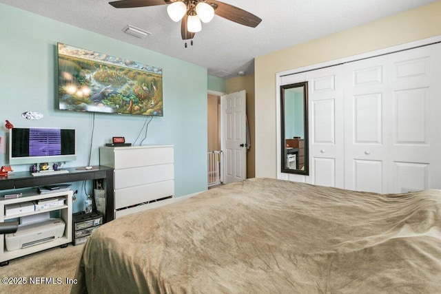 carpeted bedroom featuring a closet, visible vents, and ceiling fan