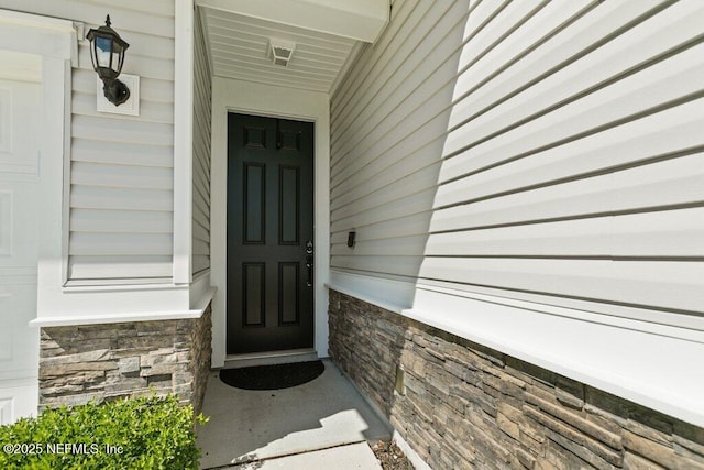 entrance to property with stone siding and covered porch