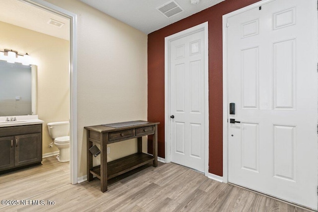 entrance foyer featuring light wood-style floors, visible vents, and baseboards