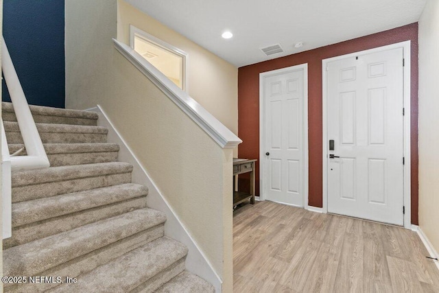 entrance foyer featuring stairway, recessed lighting, visible vents, and light wood-type flooring