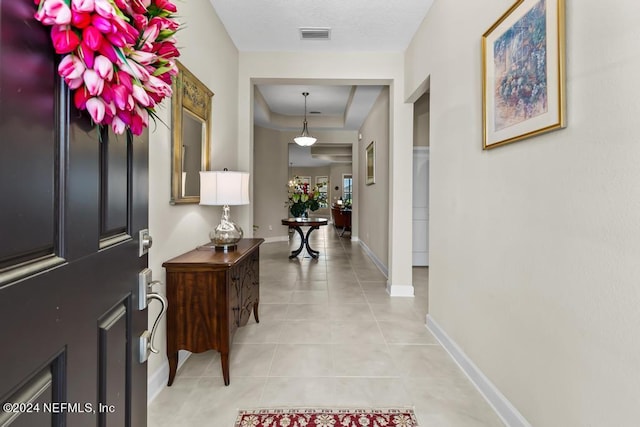 tiled foyer entrance with a raised ceiling