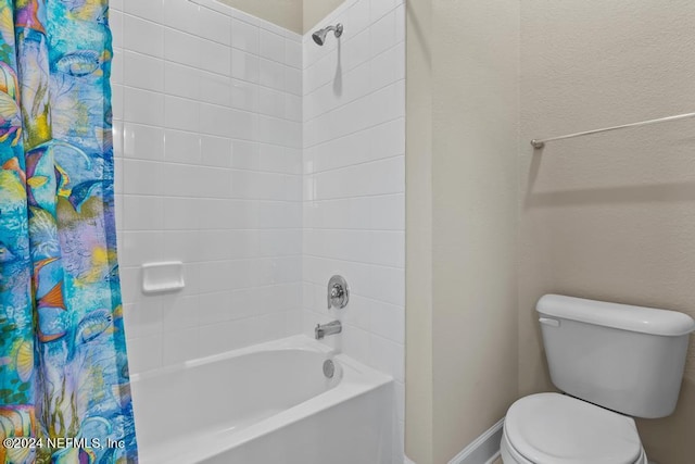 bathroom featuring shower / bathtub combination with curtain and toilet