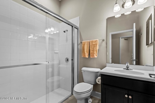 bathroom featuring oversized vanity, toilet, and a shower with door