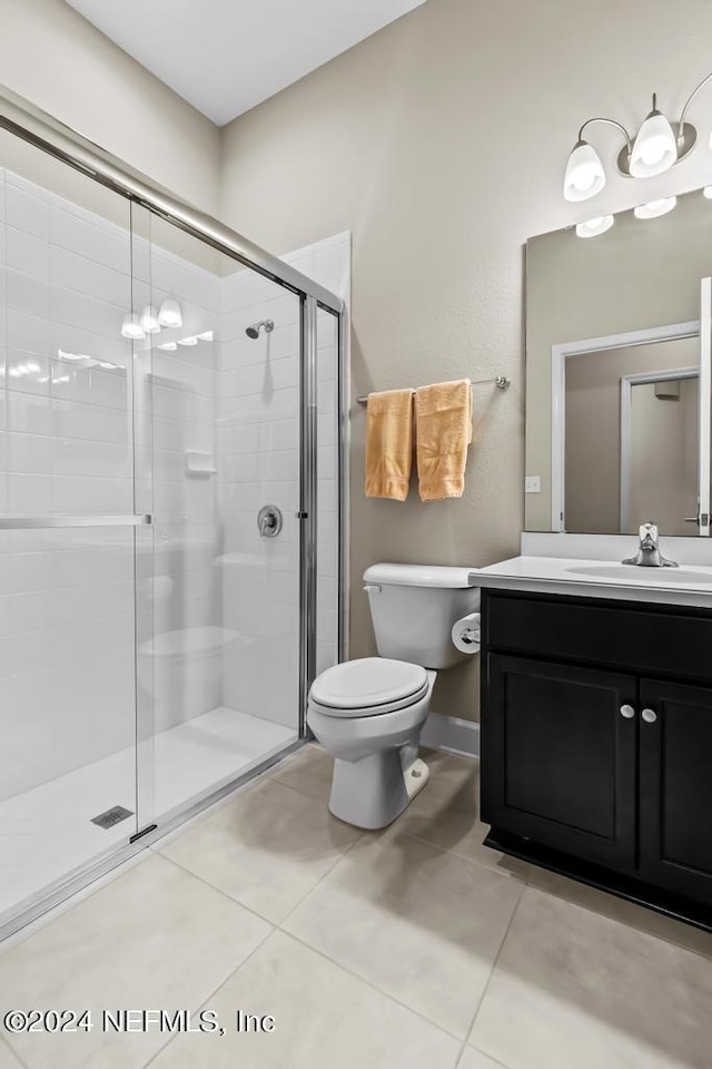 bathroom featuring tile flooring, an enclosed shower, vanity, and toilet