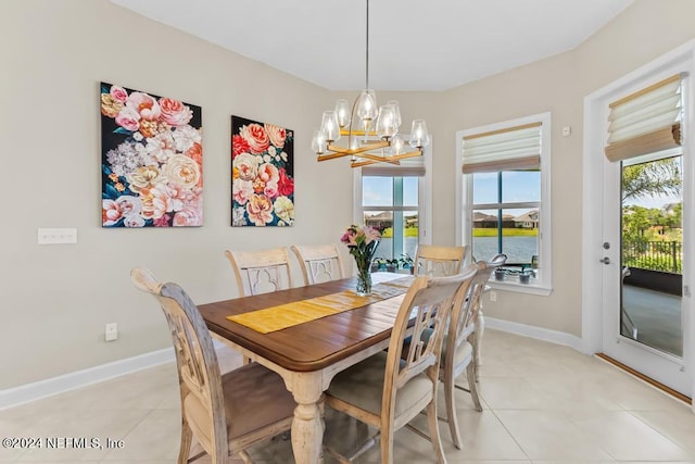 dining space with an inviting chandelier, a water view, and light tile floors